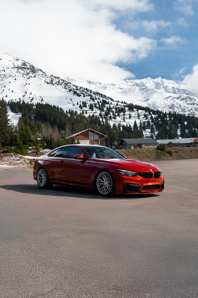 BMW rouge sur un parking de montagne enneigée