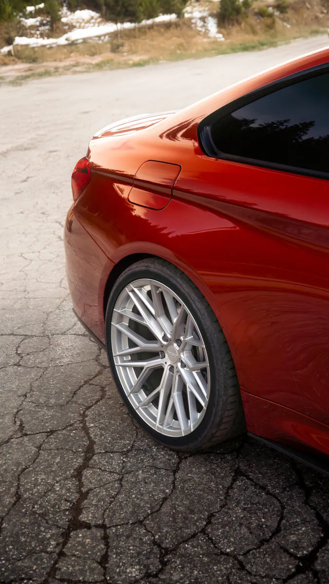 Roue arrière d'une BMW rouge sur l'asphalte