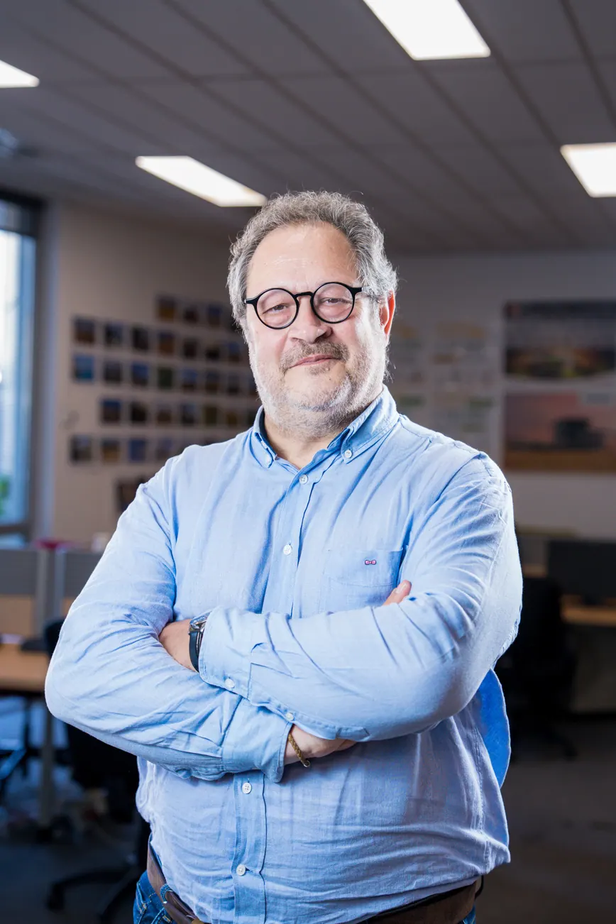 Portrait corporate debout au bureau, bras croisés : collaborateur en chemise bleu clair