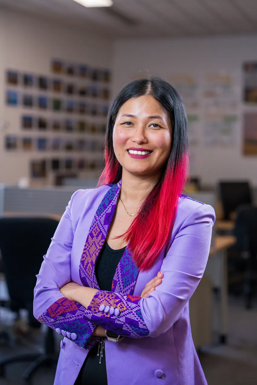 Portrait corporate debout au bureau, bras croisés : collaboratrice en veste violette