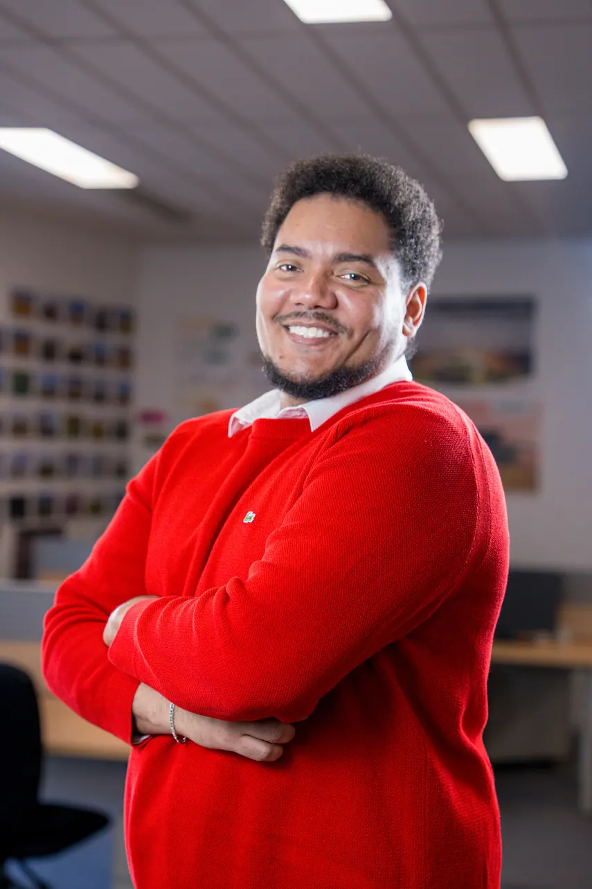 Portrait corporate debout au bureau, bras croisés : collaborateur en pull rouge