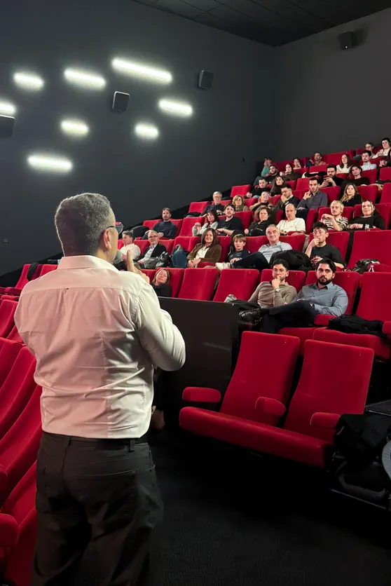 Conférence dans une salle de cinéma aux fauteuils rouges