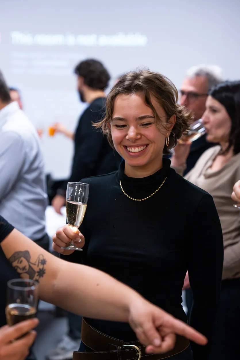 Invitée qui rit, une coupe à la main, pendant un afterwork