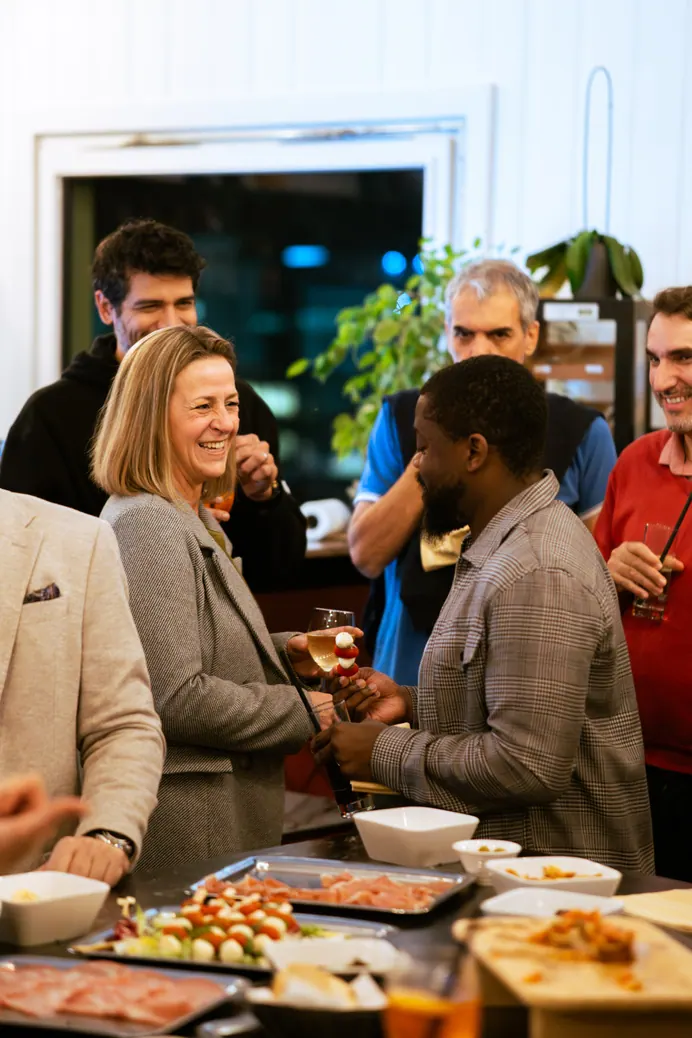 Invités qui rient en groupe pendant un cocktail