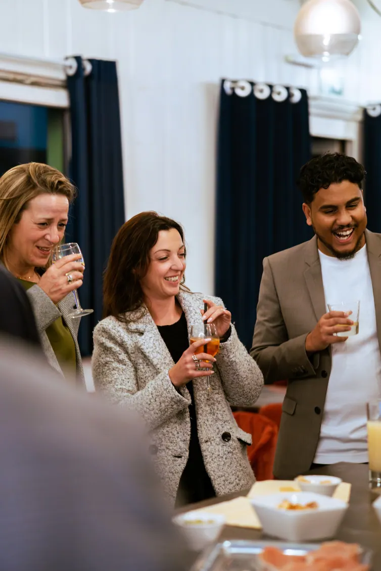 Trois invités souriants, une coupe à la main