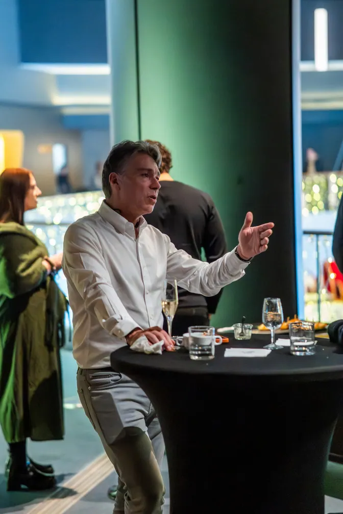 Invité qui parle avec les mains, à une table haute