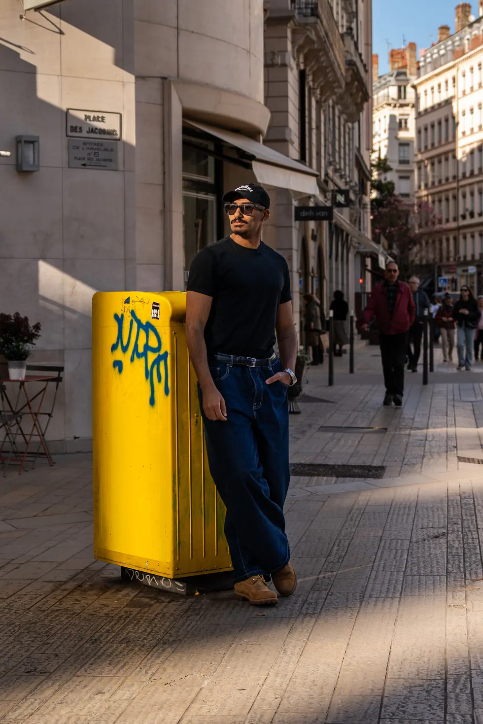 Portrait en rue, devant une poubelle jaune taguée