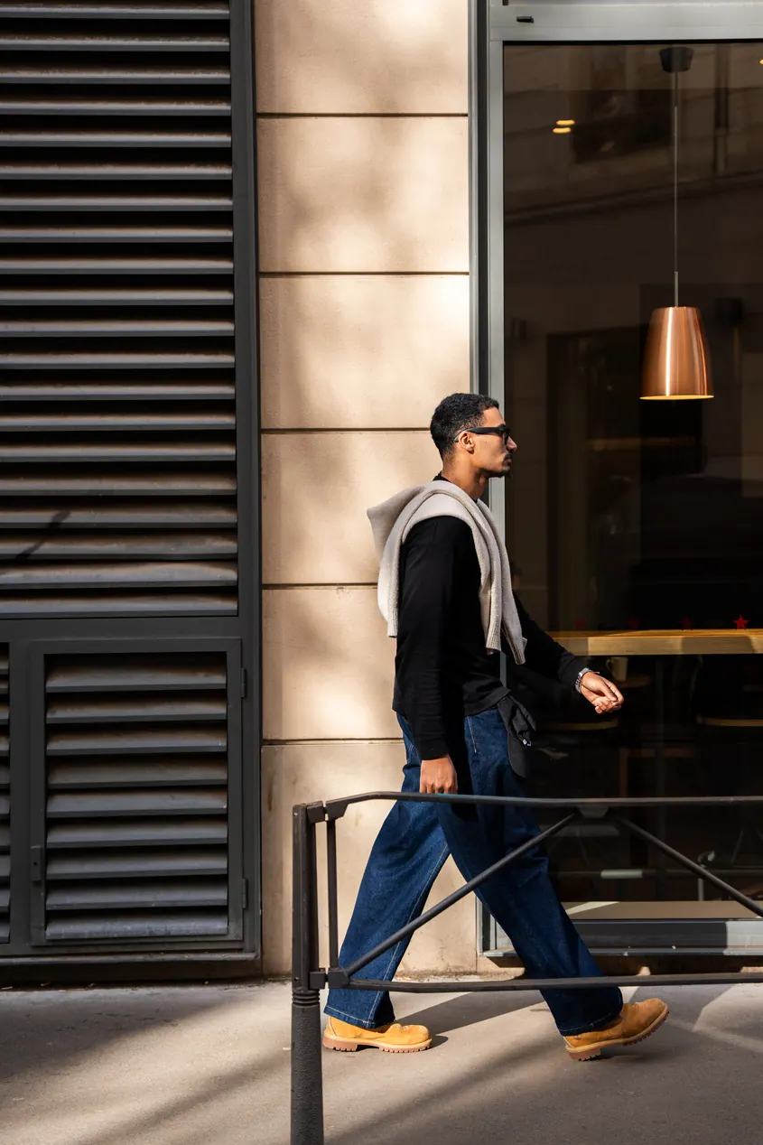 Homme qui marche devant une façade moderne