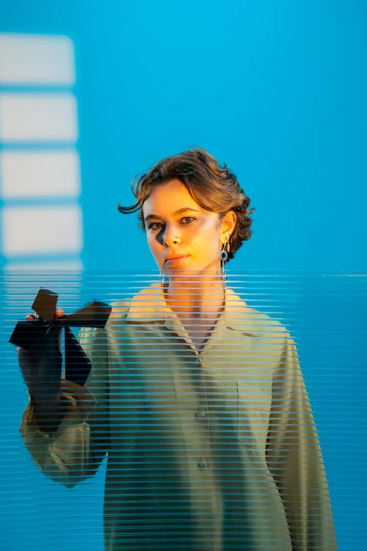 Femme sur fond bleu, objet à la main