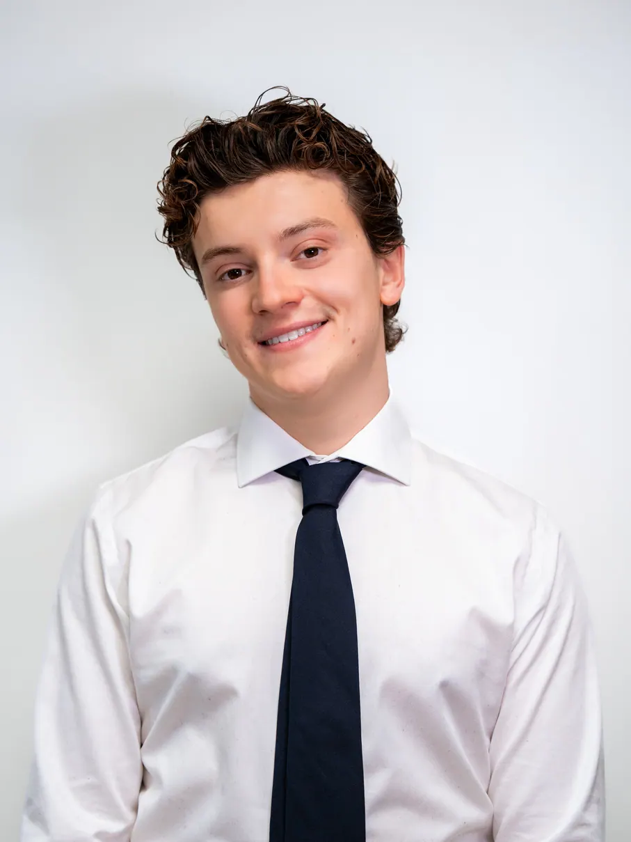 Jeune homme souriant en chemise et cravate, fond blanc