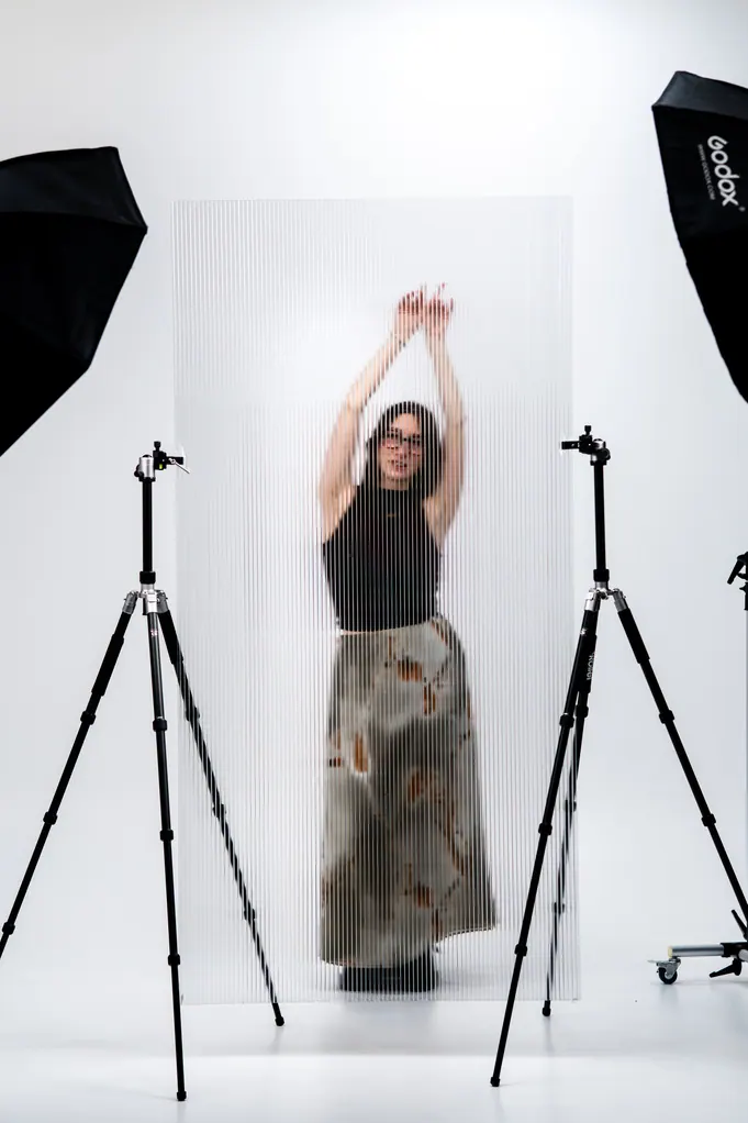 Femme bras levés entre deux éclairages de studio