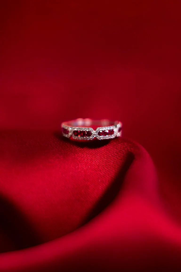 Bague posée sur un tissu satiné rouge