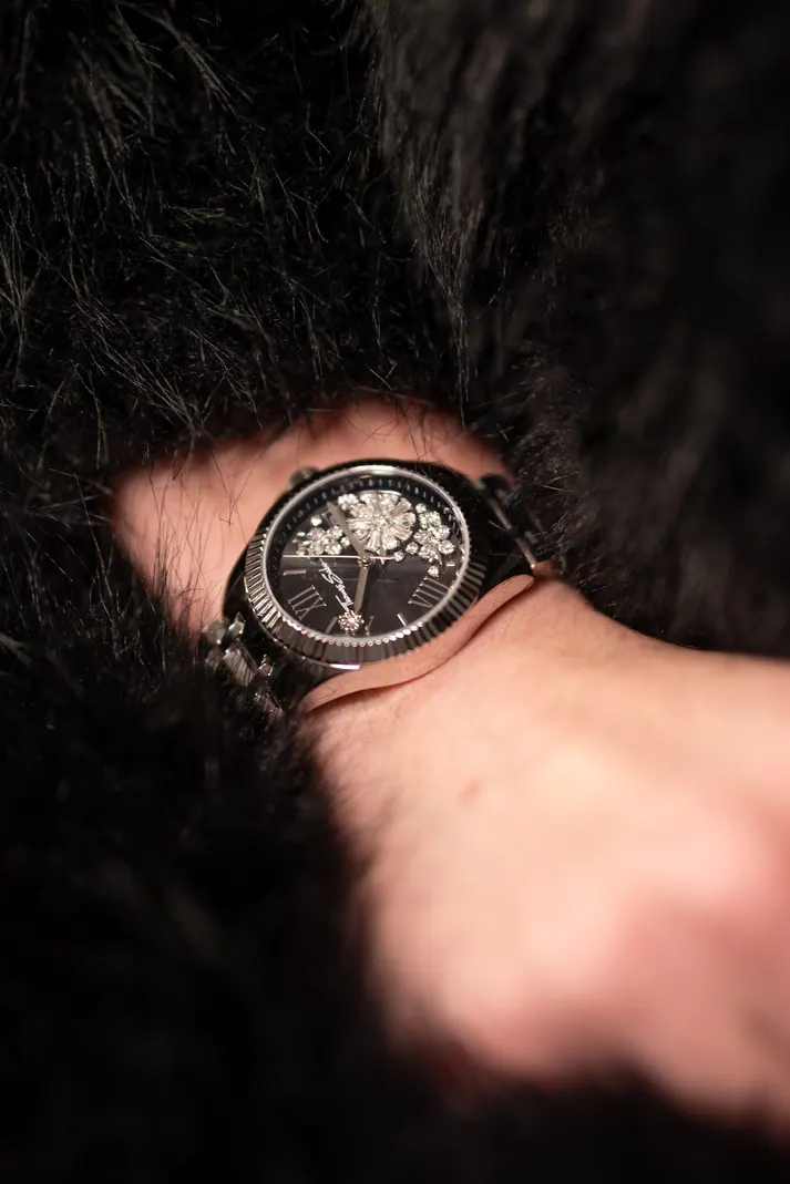 Montre au poignet, posée sur une fourrure noire