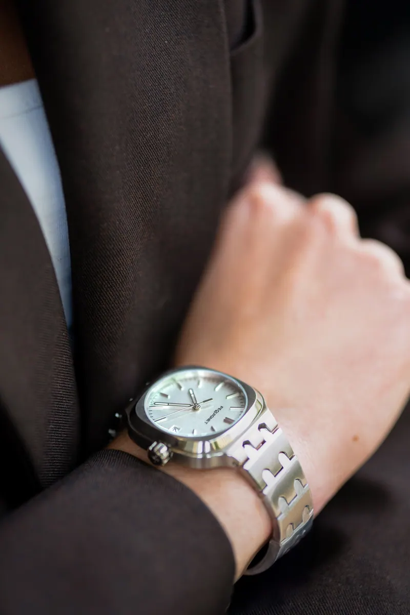 Montre au poignet, manche sombre