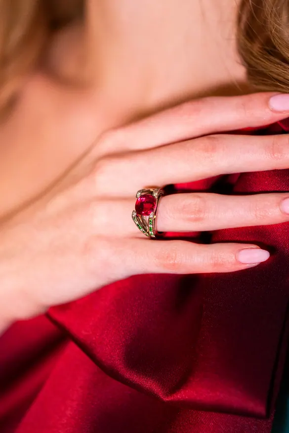 Bague à pierre rouge portée, fond rouge