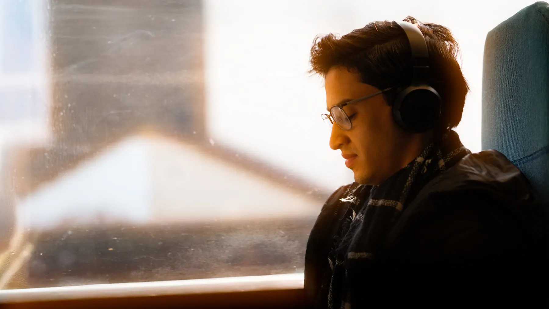 Passager au casque audio, à la fenêtre d'un train