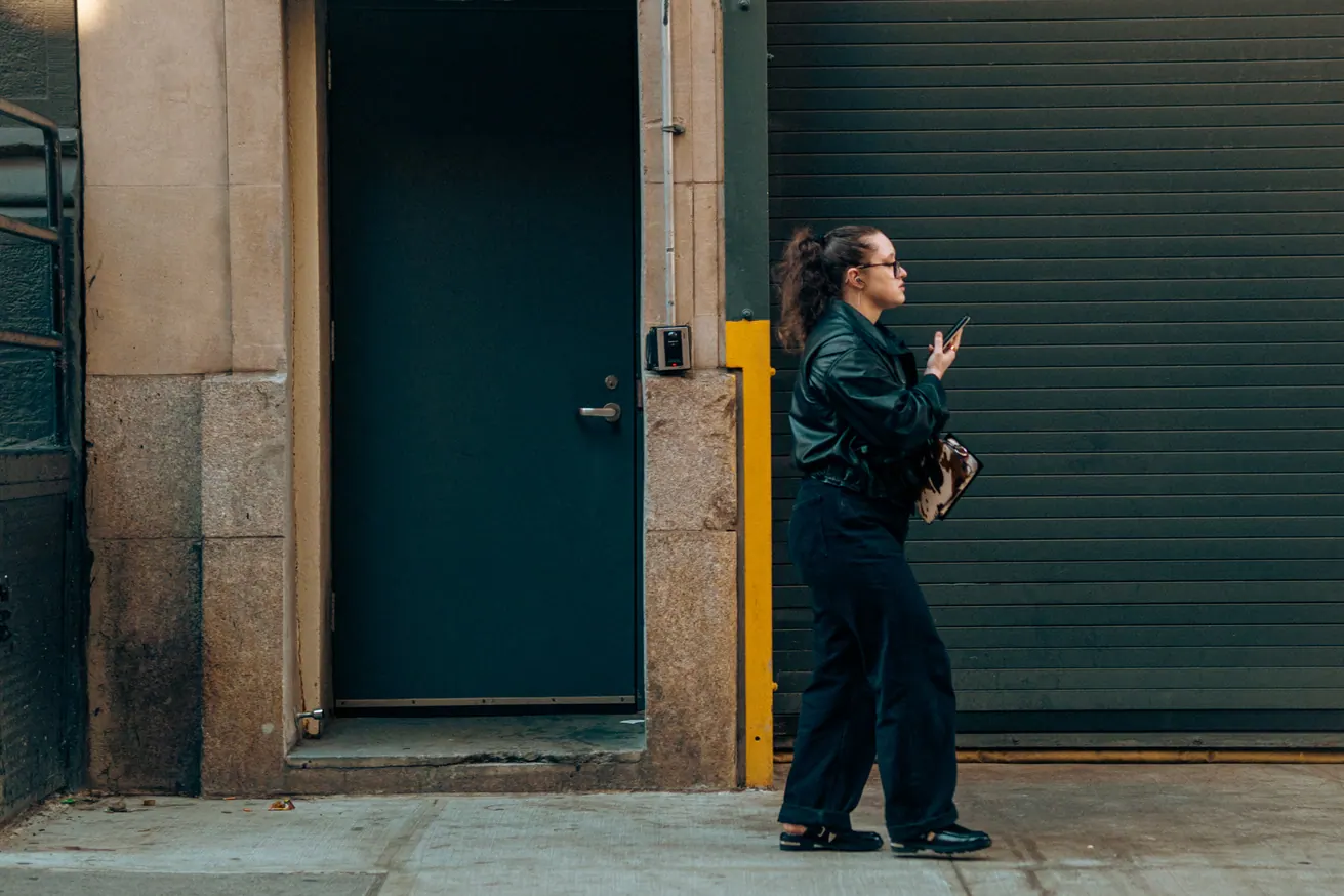 Femme en noir sur un trottoir